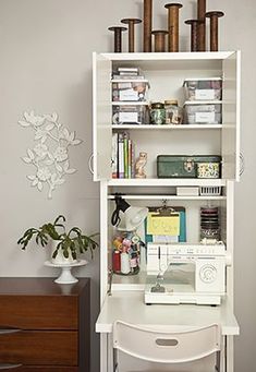 a sewing machine sitting on top of a white desk next to a wooden dresser and chair