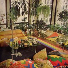 a living room filled with lots of furniture and plants