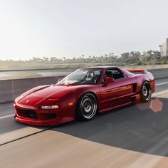 a red sports car driving down the road