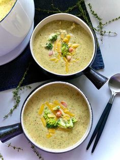 two bowls of soup with broccoli, cheese and other toppings on the side