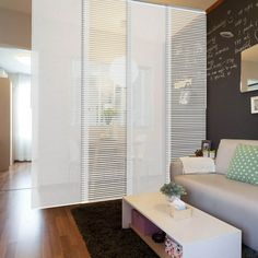 a living room with a couch, coffee table and chalkboard on the wall behind it