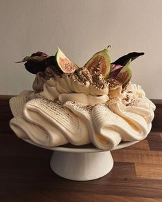 a white bowl filled with sliced figurines on top of a wooden table next to a wall