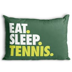 a green pillow with the words eat sleep tennis printed on it and yellow letters below