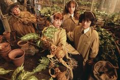 four children are sitting in front of plants