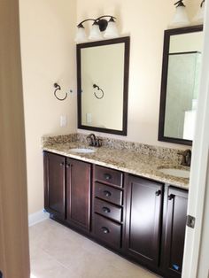 a bathroom with double sinks and two mirrors