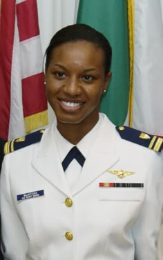 a woman in uniform standing next to flags