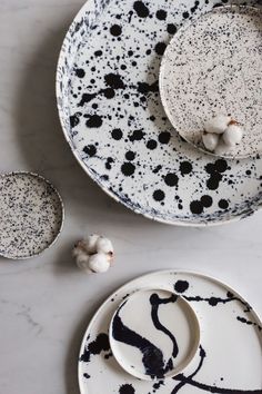 two black and white plates sitting on top of a table next to garlic cloves