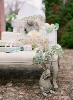 a small rabbit sitting on top of a white bench next to a pile of presents