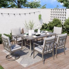 an outdoor dining table and chairs on a deck