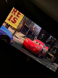 cars are shown on the screen in front of a movie theater sign that says cars