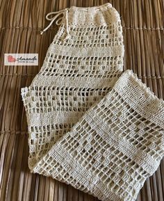 two pieces of crocheted cloth sitting on top of a wicker mat