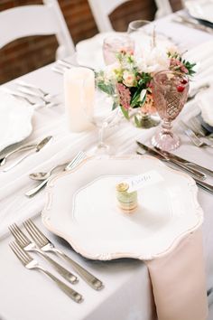 the table is set with silverware and white linens for an elegant wedding reception