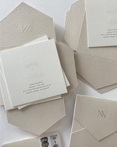 the wedding stationery is laid out on top of each other, including an envelope