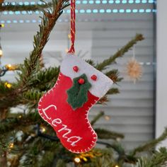 an ornament hanging from a christmas tree decorated with red and green stocking