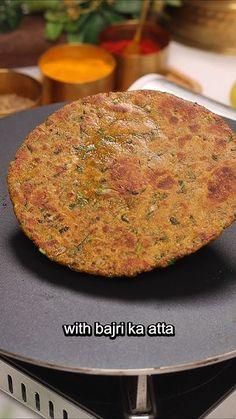 a pancake sitting on top of an electric stove with the words, with bojji ka atta written below it