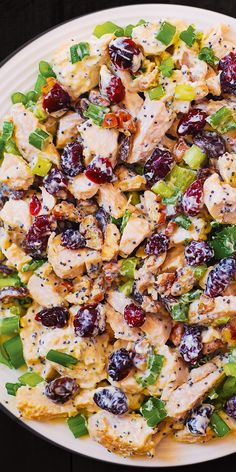 a white plate topped with chicken and cranberry salad