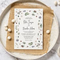 a white and gold wedding card on top of a plate