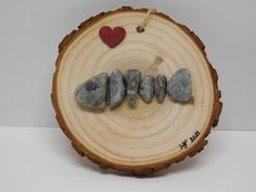 a piece of wood with some rocks and a red heart on it that says love