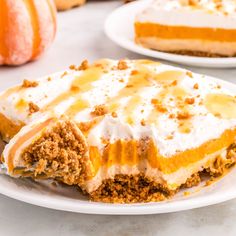 a slice of pumpkin pie on a plate with the rest of the pie in the background