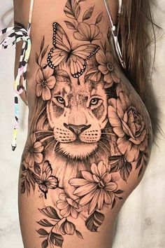 a woman's thigh with a lion and flowers on it