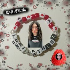 a girl with long hair is surrounded by red and white beads that spell out love