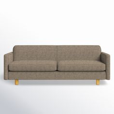 a beige couch sitting on top of a white wall