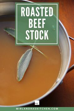 a close up of a bowl of soup with a leaf on top and the words roasted beef stock above it