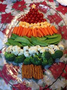 a plate with vegetables and crackers arranged in the shape of a pyramid on it