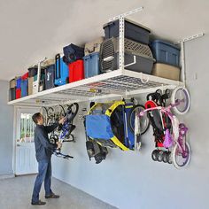 a man standing in front of a white wall filled with lots of luggage and bags