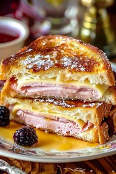 a ham and cheese sandwich on a plate with berries