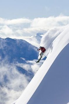 a person skiing down the side of a snow covered mountain