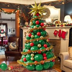 a christmas tree decorated with red and green balloons in a living room next to a fireplace