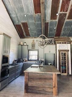 an old tin ceiling in a kitchen with wood flooring and white painted walls, along with stainless steel appliances