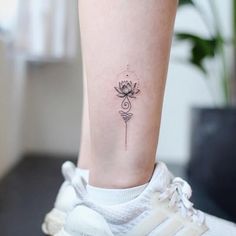 a woman's foot with a small flower tattoo on her left side calfocks