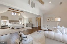 a large bedroom with white furniture and wood floors is pictured in this image from the living room