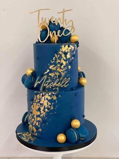 a blue and gold wedding cake with the words twenty one written on top, surrounded by confetti balls