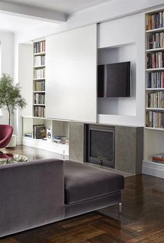 a living room filled with furniture and a flat screen tv mounted to the wall next to a fire place