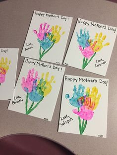 four handprinted mothers day cards on a table with the words happy mother's day