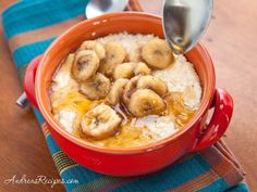 a red bowl filled with oatmeal topped with banana slices