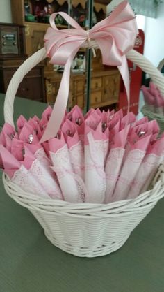 a white basket filled with pink and white umbrellas