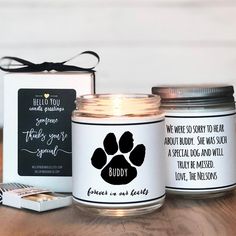 a candle with a dog paw on it next to a card and some other items