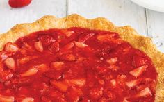 a strawberry pie on a white wooden table