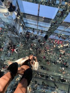 a woman taking a selfie in front of a glass building with lots of people