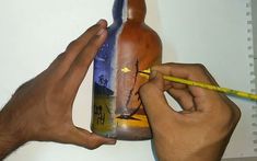 a man is painting a bottle with colored pencils