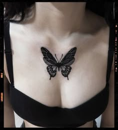 a woman's chest with a butterfly tattoo on her left side, in black and white