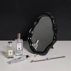 a vanity mirror, shaving brush, razor and perfume bottle