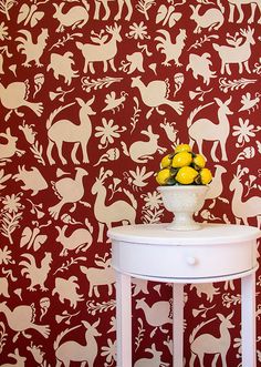 a white table topped with lemons next to a wallpapered room filled with animals