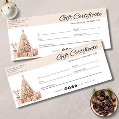 two gift certificates sitting on top of a table next to a bowl of christmas decorations