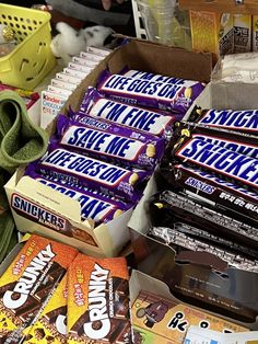 a pile of chocolate bars sitting on top of a table next to other boxes of candy