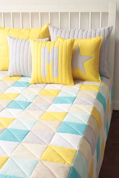 a bed with yellow and blue pillows on it